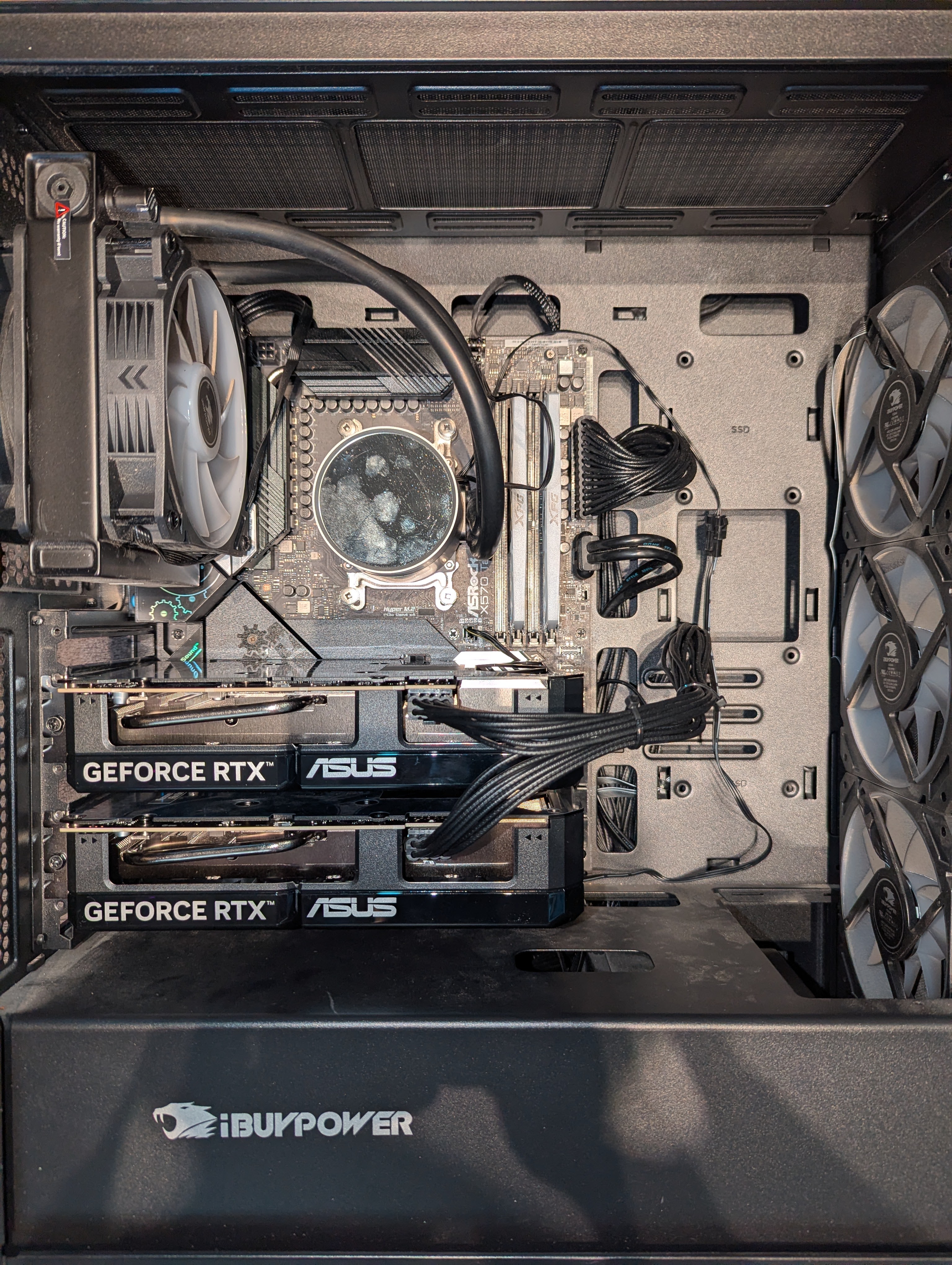 your-llm-host interior — dual ASUS RTX 5060 Ti cards mounted in PCIE1 and PCIE2 of an ASRock X570 Taichi inside an iBUYPOWER chassis with 240mm AIO cooling the Ryzen 5 5600X